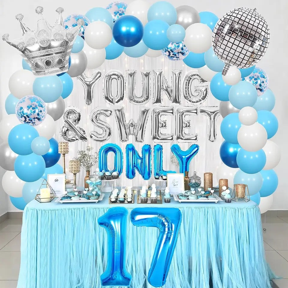 Joyous 17th birthday celebration in a festively decorated room, filled with colorful balloons, streamers, and a 'Happy 17th Birthday' banner. A table adorned with a colorful tablecloth holds a cake with lit candles and snacks, surrounded by guests in party hats, laughing and sharing a toast.